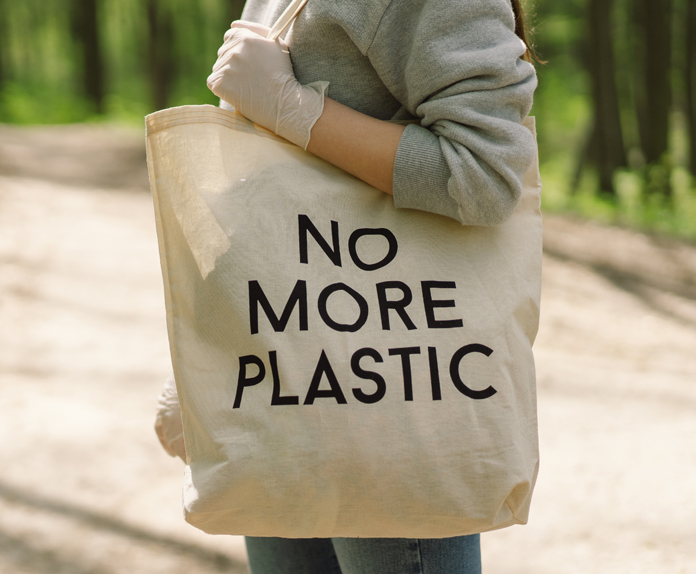 Eco-friendly totes made from natural fibers beside single-use plastic bags