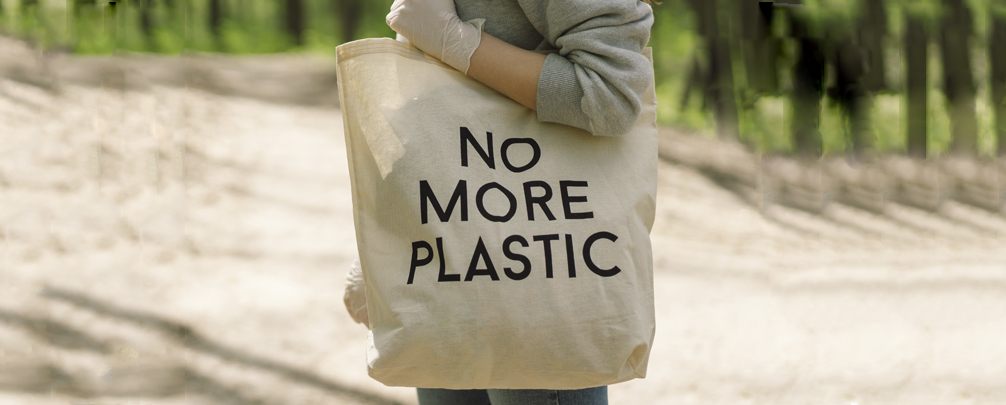 Eco-friendly totes made from natural fibers beside single-use plastic bags